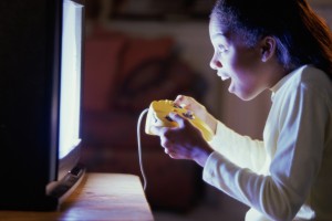 Side profile of a teenage girl playing video games